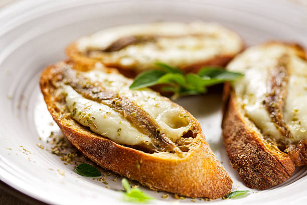 Crostini with fish, mozzarella and oregano Crostini with anchovy fish, mozzarella and oregano crostini stock pictures, royalty-free photos & images