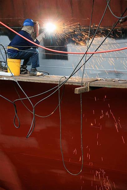 istock Welder working on side of ship in dry dock 497297905