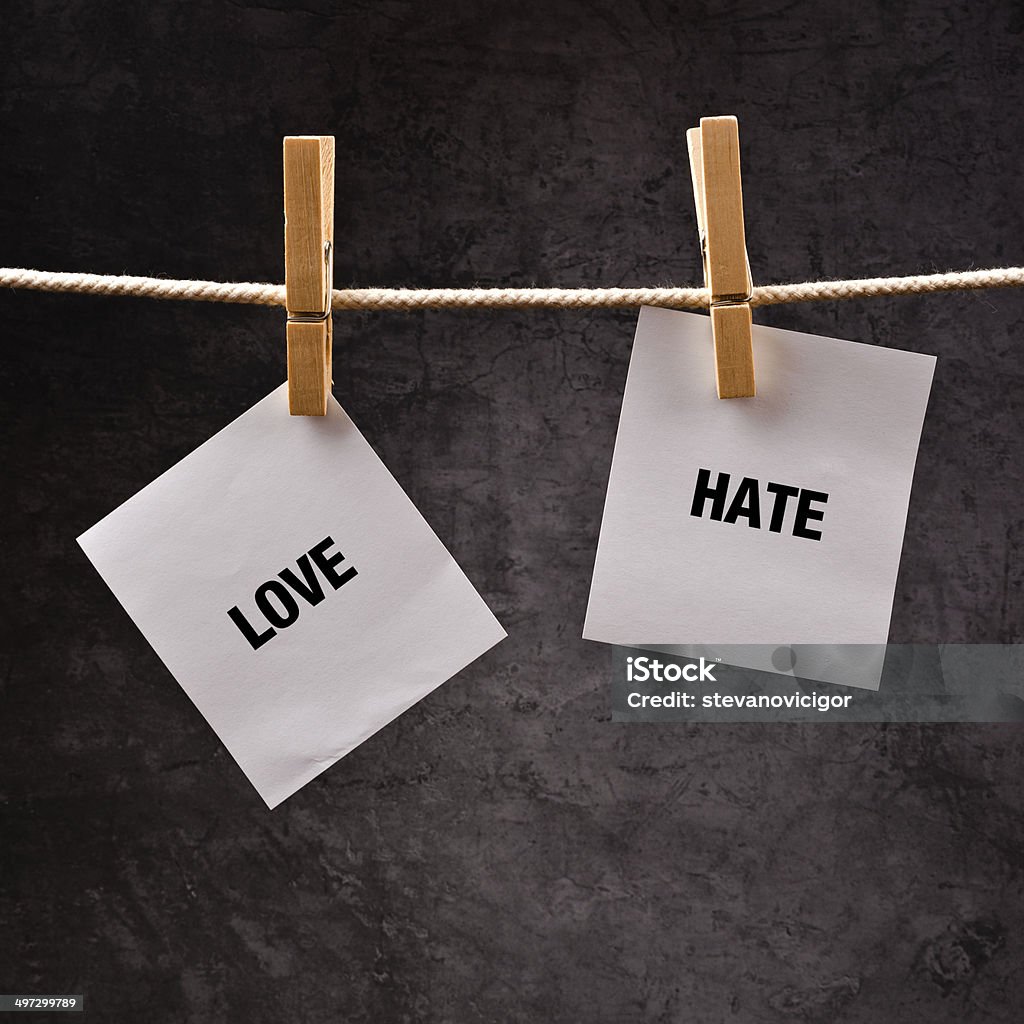 Love or hate conceptual image Love or hate conceptual image. Choose between loving and hating, words printed on hote paper attached to clothesline. Anger Stock Photo