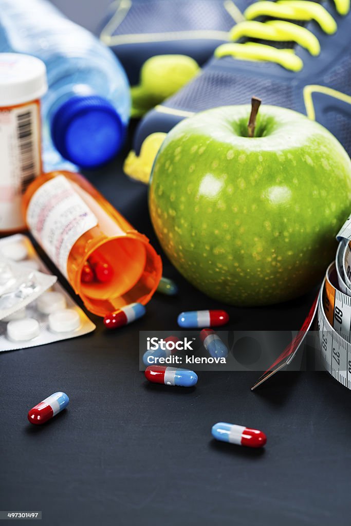 Different tools for sport and pills Different tools for sport and pills (Vitamins or Fitness Supplement) on grey background - sport, health and diet concept Capsule - Medicine Stock Photo