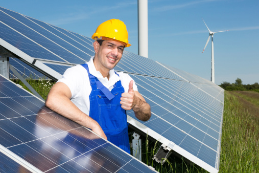 Photovoltaic engineer showing thumbs up at solar energy array
