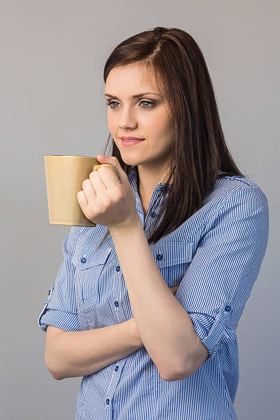 istock Pensive pretty brunette holding cup of coffee 497303569