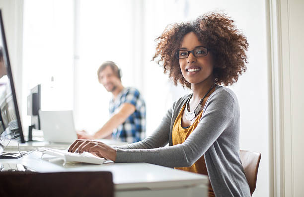 istock Happy african woman working at her desk 497306878