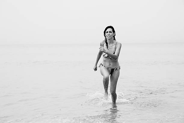 istock beautiful woman standing on the beach 497308256