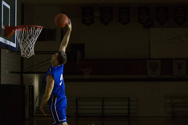 istock Young men dunking a basketball in a gymnasium 497309800