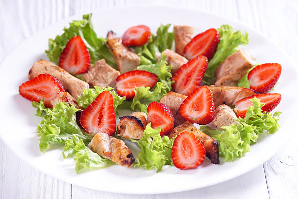 istock Chicken salad and strawberries on a white table 497310548
