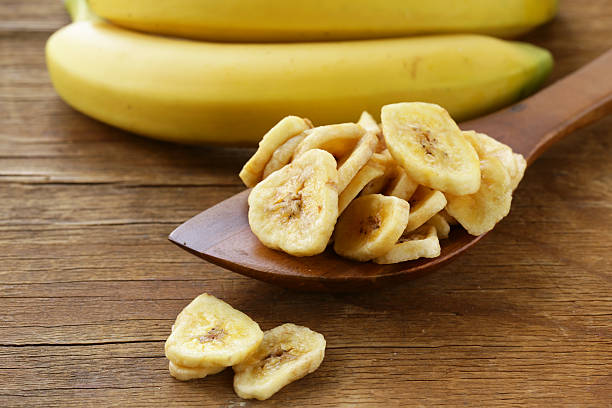 istock banana chips, dried fruit on a wooden table 497310824
