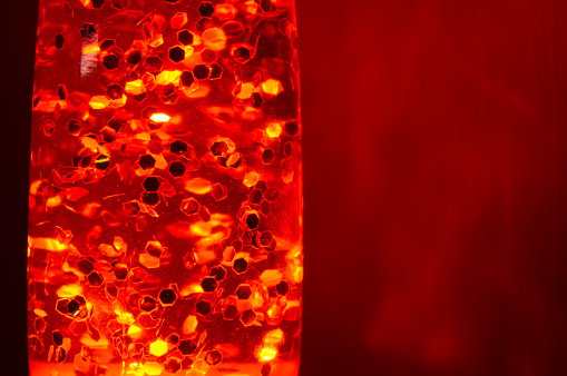 Lava lamp at night on a red background