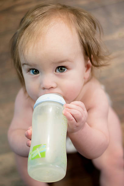 bebê com garrafa de bebida - nutral imagens e fotografias de stock
