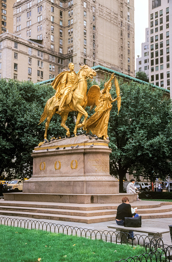 New York,USA-August 28,1999: The Sherman Monument at Grand Army Plaza near the entrance to Central Park.It was designed by sculptor Augustus St.Gaudens and erected in 1903. Some people are resting on the statue's base.   