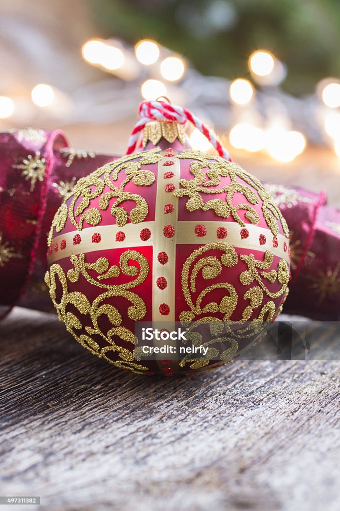 golden ball with christmas lights golden ball with red ribbon on wood, christmas defocused lights in background 2015 Stock Photo