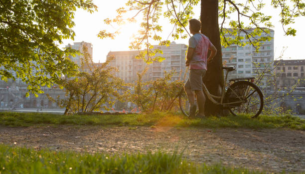 Man pausing with bike to look out across river