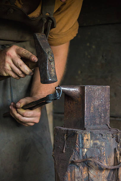 Blacksmith Working with his Tools A Blacksmith with his pilers, hammer and anvil. ribe town photos stock pictures, royalty-free photos & images