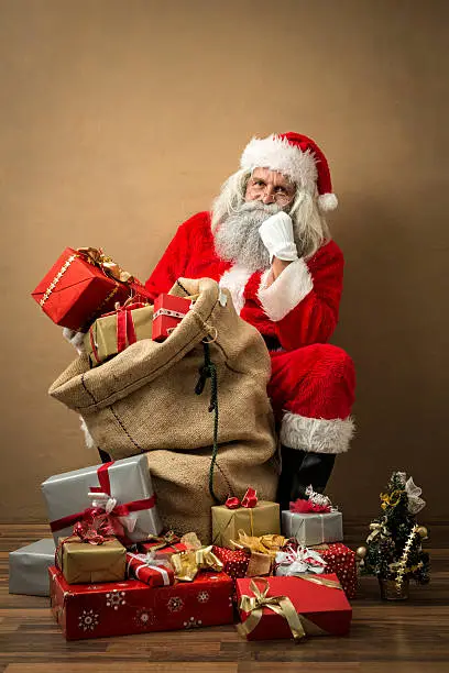 Photo of santa claus with many gifts in his bag