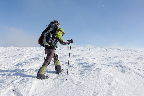 istock Backpacker woman is walking in winter mountains on sunny day 497320404