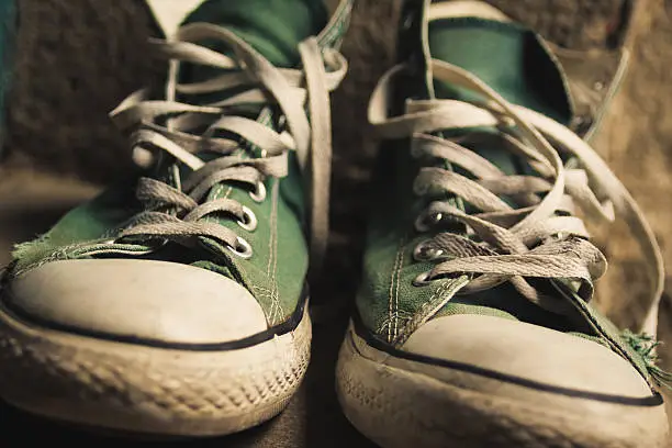 Old green converse shoes and worn laces