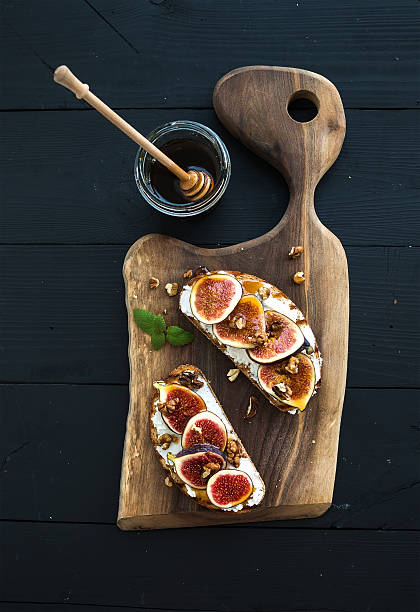 istock Sandwiches with ricotta, fresh figs, walnuts and honey on rustic 497345968