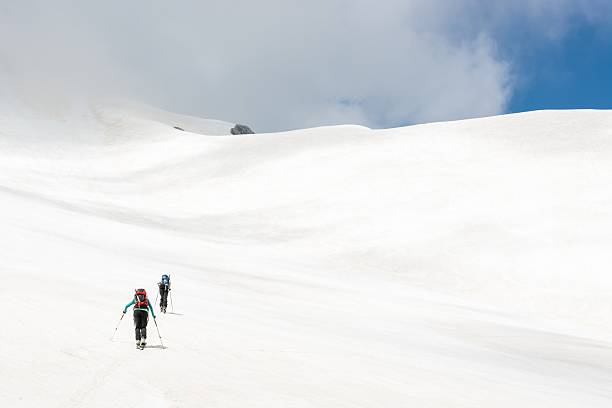 istock Skiiers ascending mountain slope 497346639