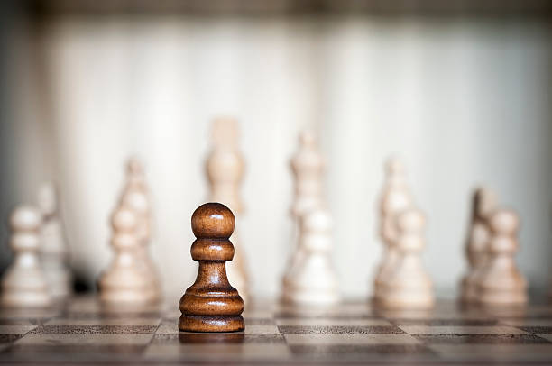 lone preto peão frente de um exército branco - chess defending chess piece chess board - fotografias e filmes do acervo