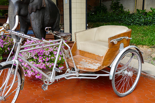 Chiang Mai, Thailand - November 3, 2015: old classic traditional asian tricycle with beige leather cushion showing in front of Chiang Mai Orchid hotel.