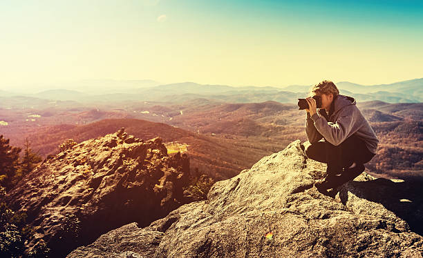 istock Man with a camera on top of a cliff 497348830