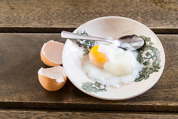Asian Chinese half soft boiled egg on sauce Asian Chinese half soft boiled egg served on old fashioned Oriental saucer kopitiam egg stock pictures, royalty-free photos & images