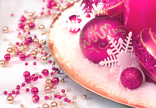 Christmas Table Decorations in fuschia pink and gold with white snow and snowflakes
