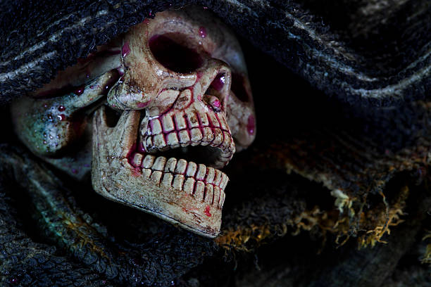 istock skull in the cloth wrap and blood  over black. 497349648