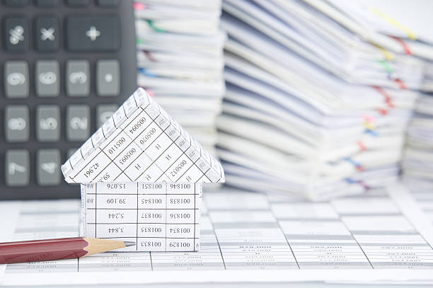 istock Pencil and house have blur calculator and paperwork as background 497352148
