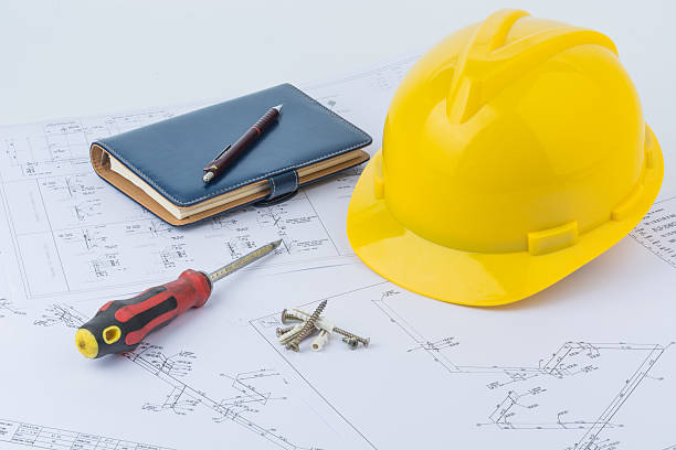 istock Yellow safety helmet, notebook and screwdriver 497354710