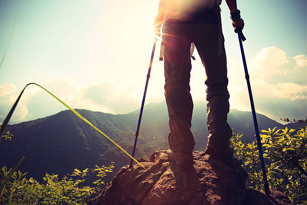istock woman hiker legs stand on mountain peak rock 497355306