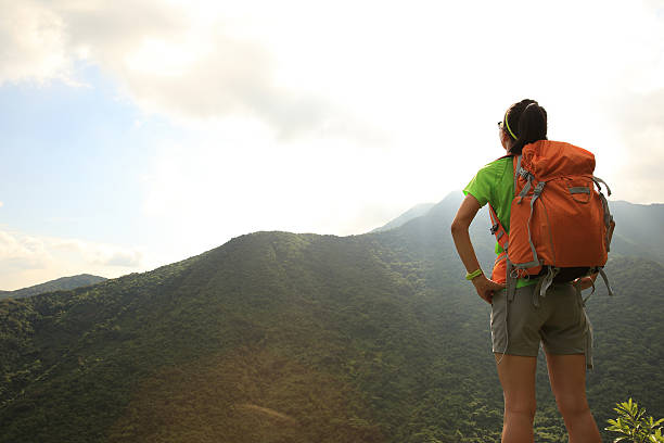 istock woman backpacker on mountain peak enjoy the view 497355598