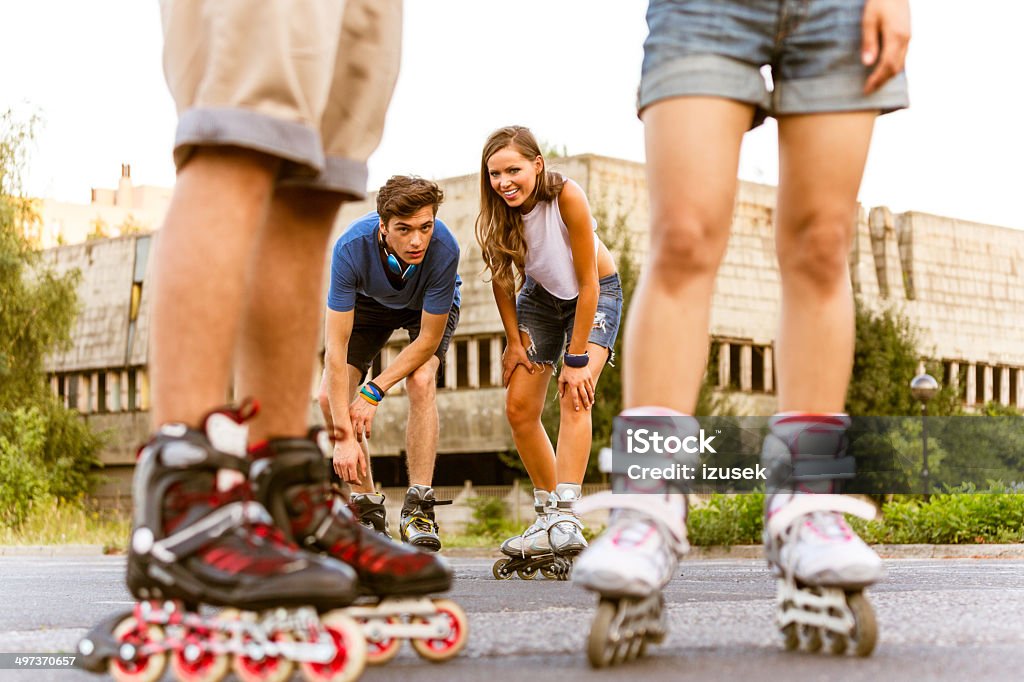 Young people on rollerblades Group of happy young people rollerblading together. Focus on the couple in the background. 20-24 Years Stock Photo