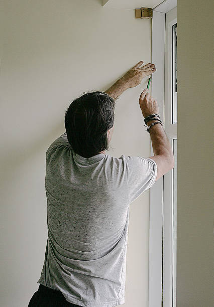 istock Tradesman measuring a newly installed pvc window 497372153