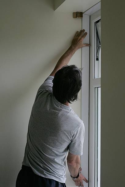 istock Tradesman finishing off installing a pvc window 497372197