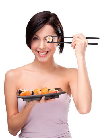 Black-haired girl holding sushi with a chopsticks, isolated