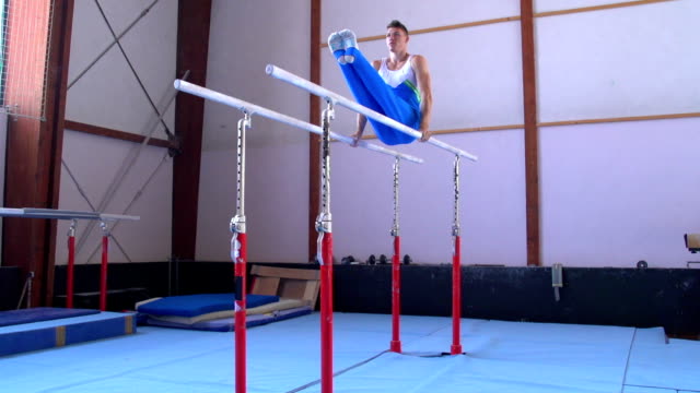 HD:Shot of Male Gymnast Performing Routine on Parallel Bars