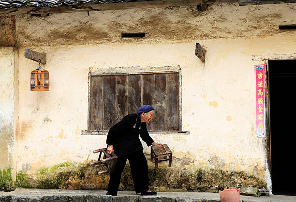 Hmong woman from Vietnam Ha Giang, Viet Nam - September 2, 2012: H'mong woman is taking two chairs to come back home in Hagiang, Vietnam bac ha market stock pictures, royalty-free photos & images