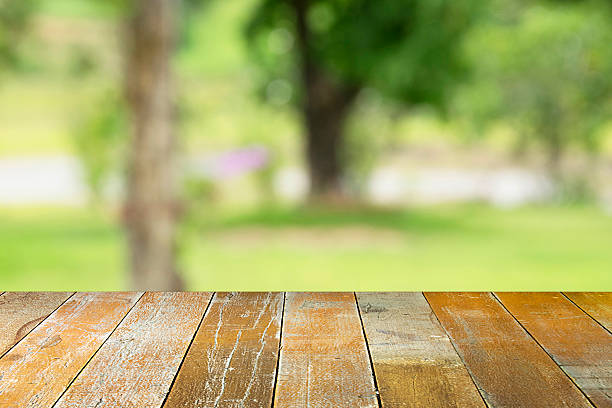 istock Empty top wooden table and sunny abstract blurred background 497384770