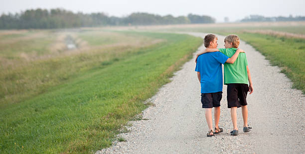 istock Two Boys Walking Down a Country Road 497387345