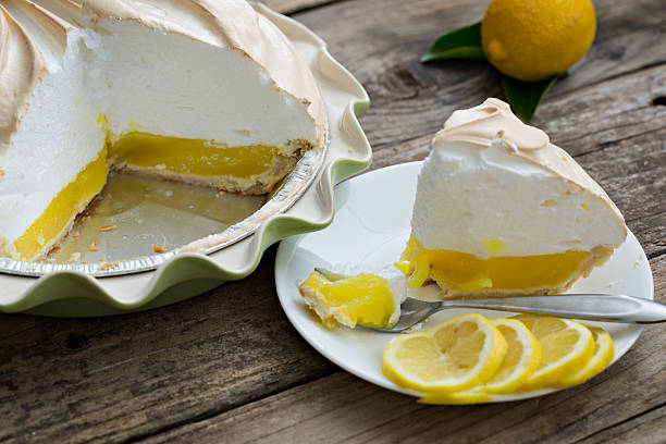 Lemon Meringue Pie A high angle extreme close up shot of a lemon meringue pie and some lemon slices. meringue stock pictures, royalty-free photos & images