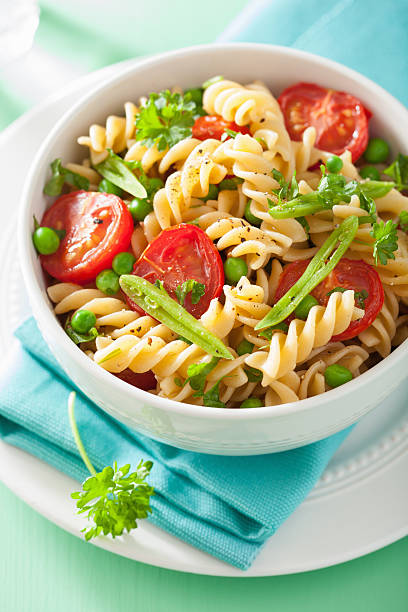 istock vegetarian pasta fusilli with tomato peas herbs 497388924