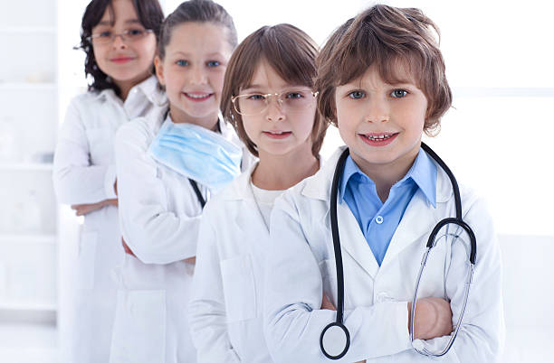 istock Smiling team of little doctors looking at camera. 497390400