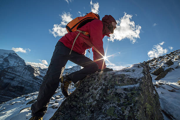 istock Young man climbs steep rock, moving up 497391482