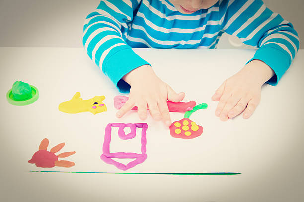 istock little boy playing with clay dough, education and daycare 497392692