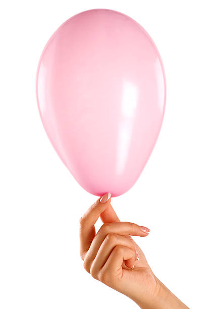 istock female hand holding a small pink baloon 497393821