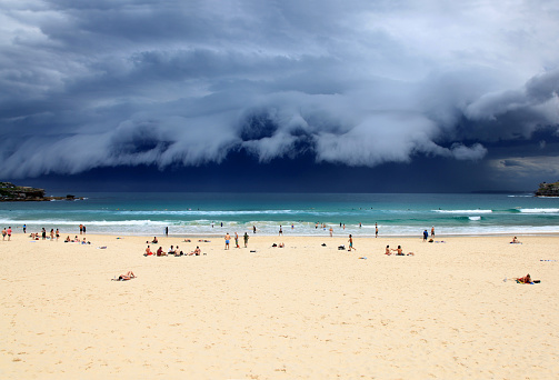 Bondi Beach - Sydney Australia. Beach goers enjoy the last rays of sunshine before a massive storm sweeps through Sydney