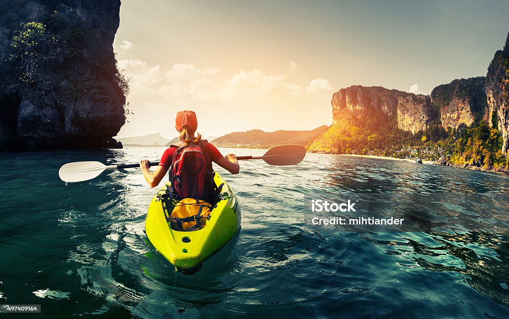 Lady with kayak Lady paddling the kayak in the calm tropical bay at sunset Adventure Stock Photo