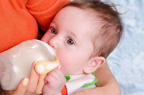 istock Six month old baby drinking milk from a bottle 497410077