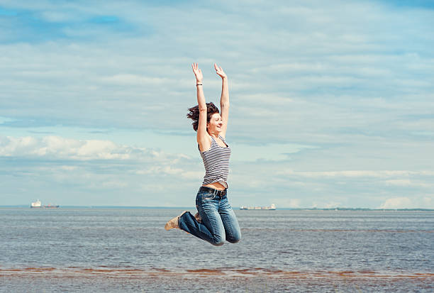 istock Happy woman jumping on the beach 497411377